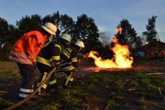 Geduckte Feuerwehrleute vor Feuer